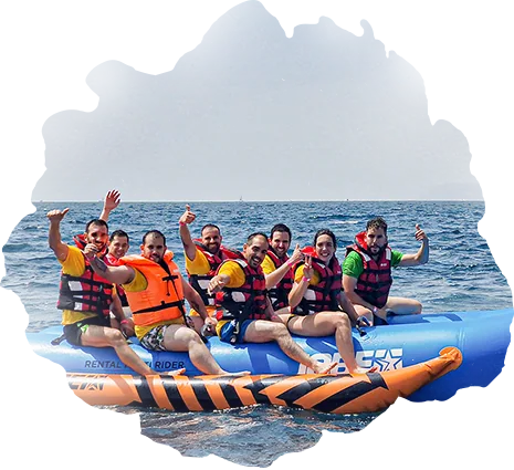 Un grupo de clientes de Grupo Marina Jets sobre una banana hinchable en el mar