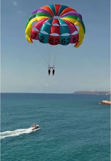 Dos clientes de Grupo Marina Jets haciendo parasailing sobre el mar