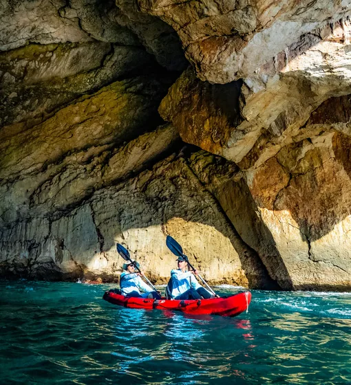 Two Moraira Boats customers kayaking inside a sea cave on the Moraira coast